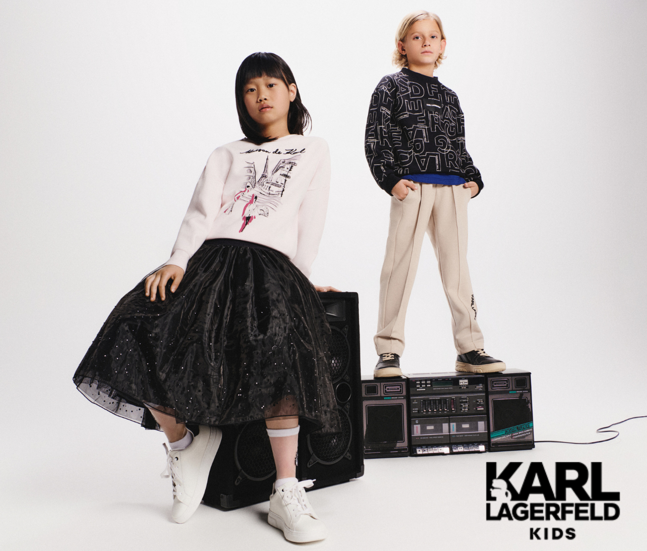 Two children modeling Karl Lagerfeld Kids clothing on a white background